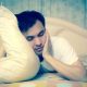 Man clutching pillow not able to sleep