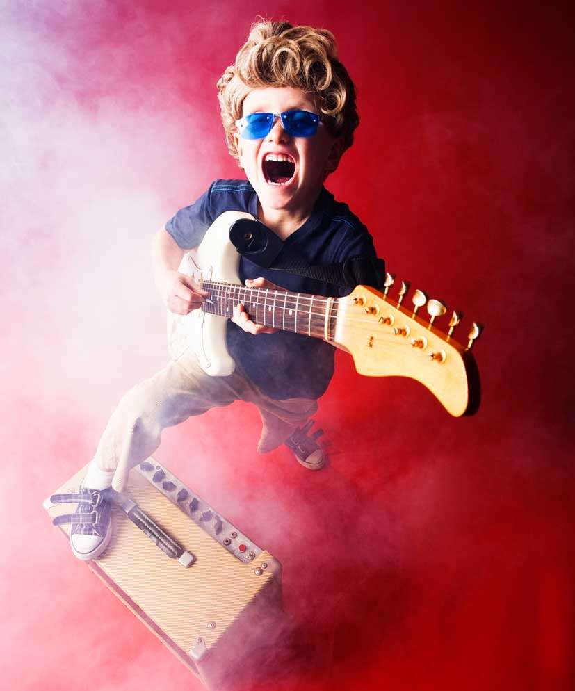 Pain amplifier - boy standing on music amp.