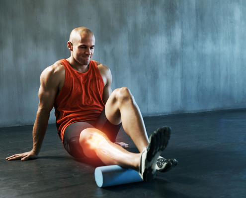 Man stretching calf with foam roller