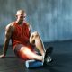 Man stretching calf with foam roller
